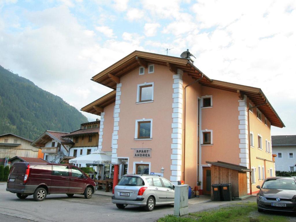 a building with two cars parked in a parking lot at Spacious Apartment in Uderns near Ski Area in Uderns