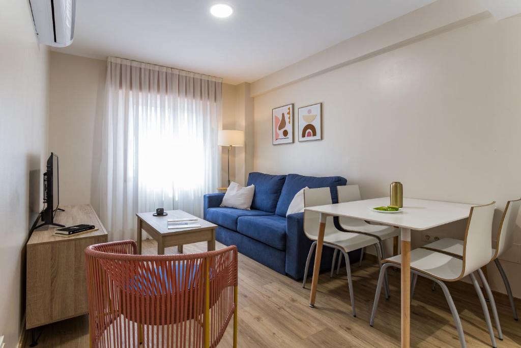 salon z niebieską kanapą i stołem w obiekcie Vigo Bay Apartments by Olala Homes w mieście Vigo