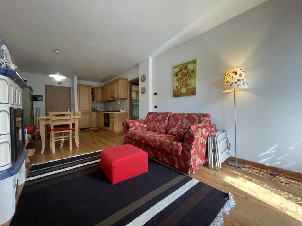 uma sala de estar com um sofá vermelho e uma mesa em 094 Trilocale, pinzolo em Pinzolo
