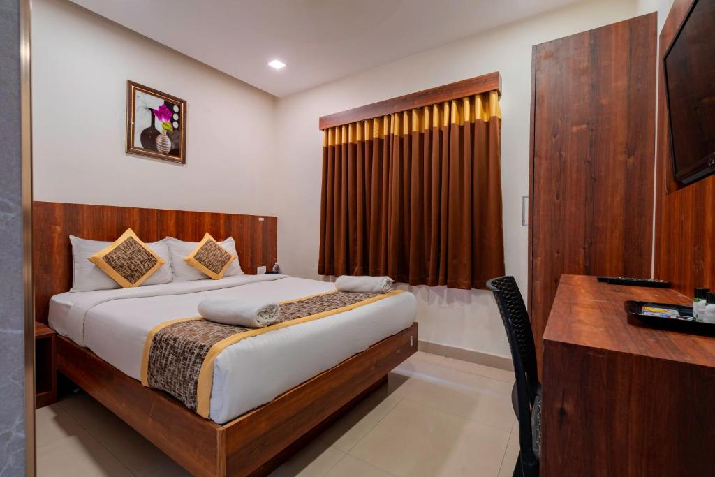 a hotel room with a bed and a desk and a desk at Prime Palace Hotel - MG Road in Cochin