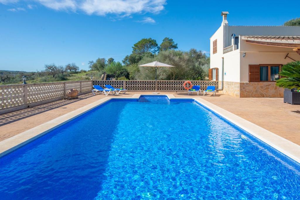 una piscina con acqua blu di fronte a una casa di Vista Sol ad Ariany