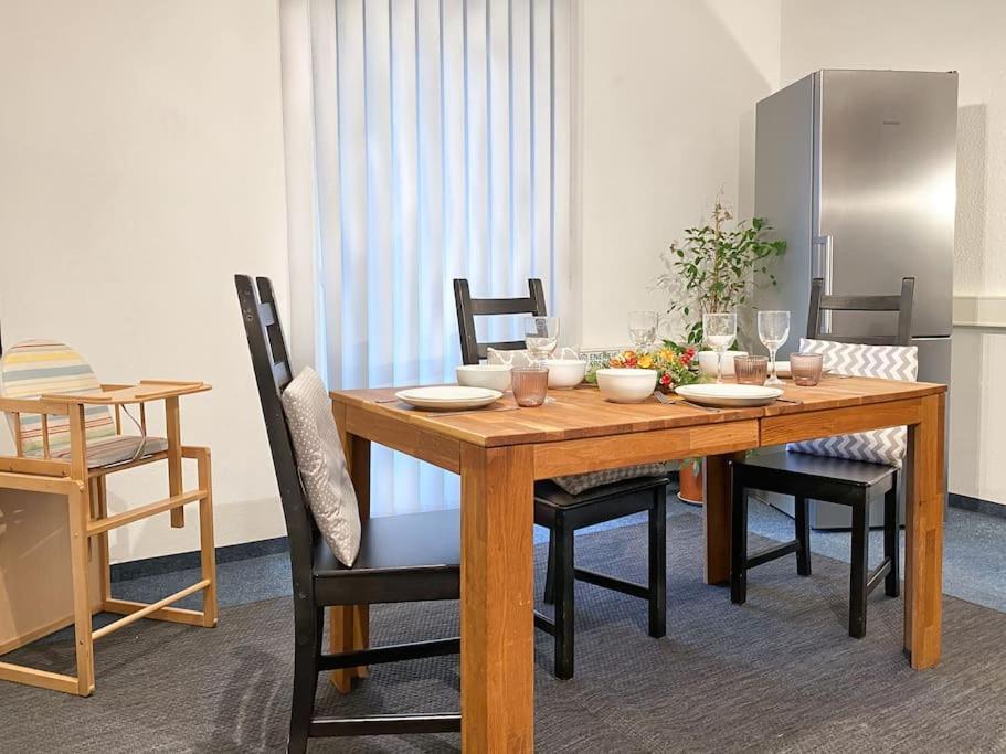 une table en bois avec des chaises et une salle à manger dans l'établissement Mountain Apartment 2. The Art to live, à Dietmannsried
