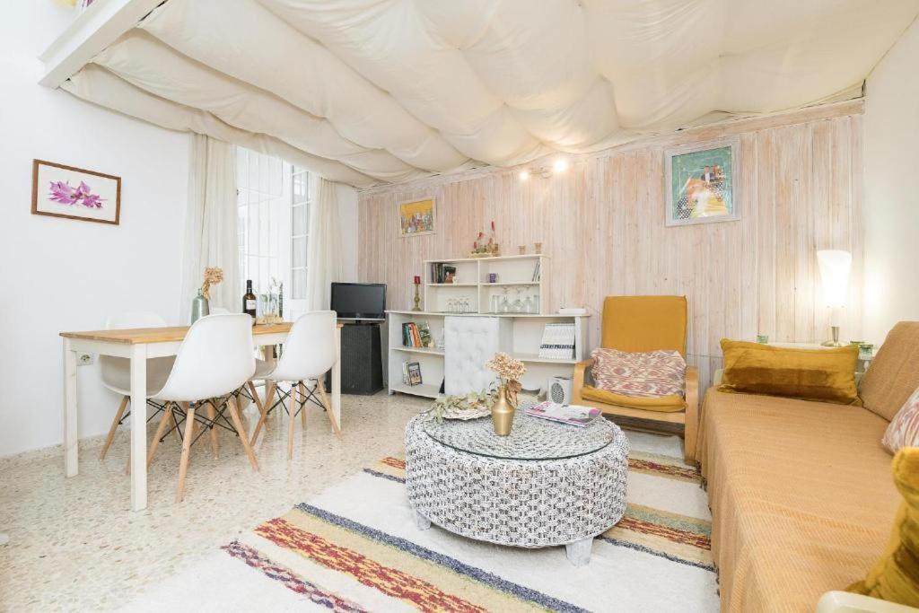 El Loft de la Reina - Apartamento Interior في خيريز دي لا فرونتيرا: غرفة معيشة مع أريكة وطاولة