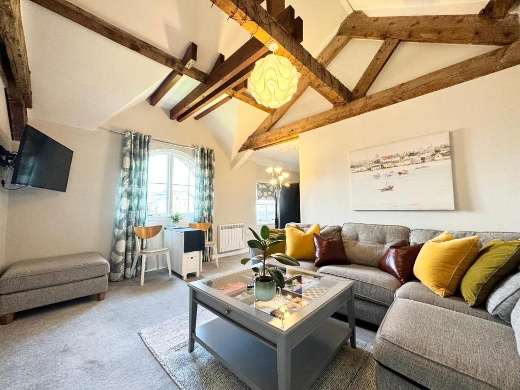 a living room with a couch and a table at The Coppersmith - Warehouse Apartments, Lake District in Ulverston