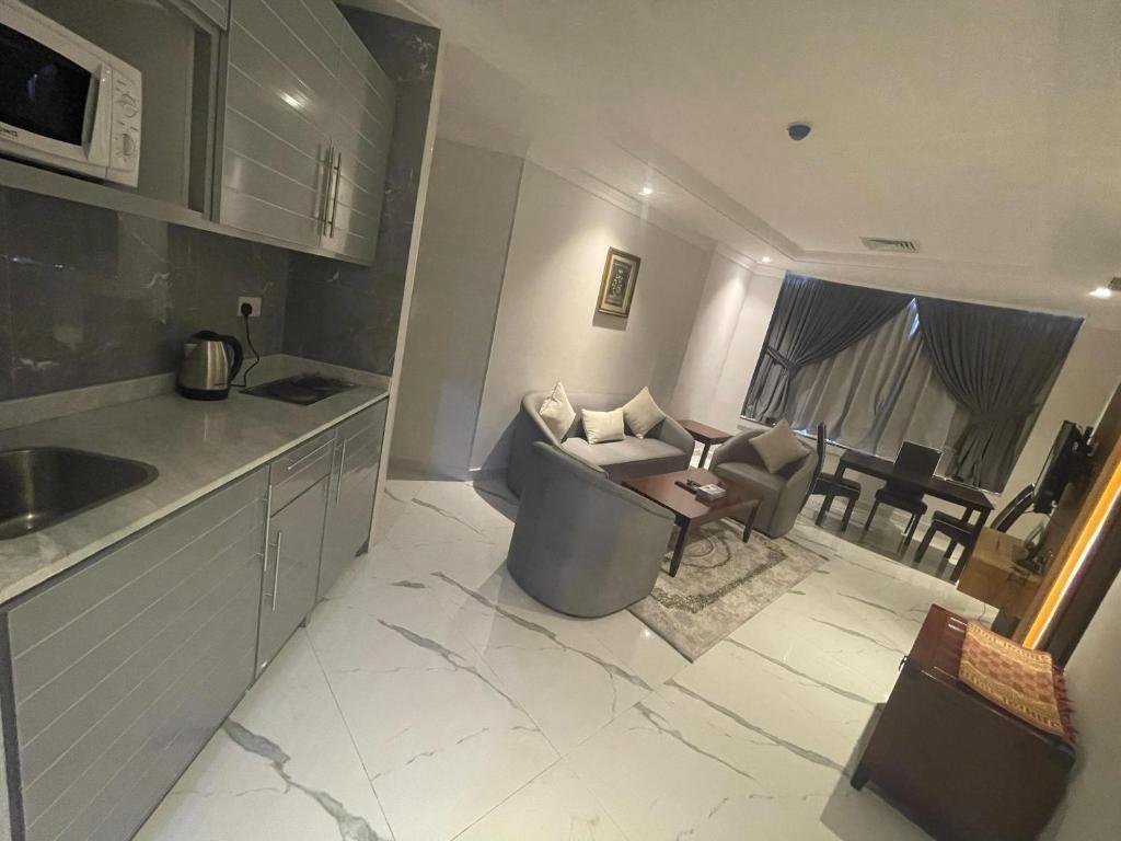 a kitchen and a living room with a couch at Continental Suite farwaniya in Kuwait