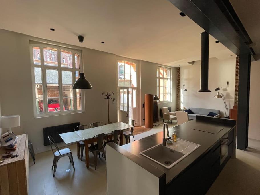 une cuisine et un salon avec un évier et une table dans l'établissement Loft convivial et spacieux, comme une maison, à Dieppe