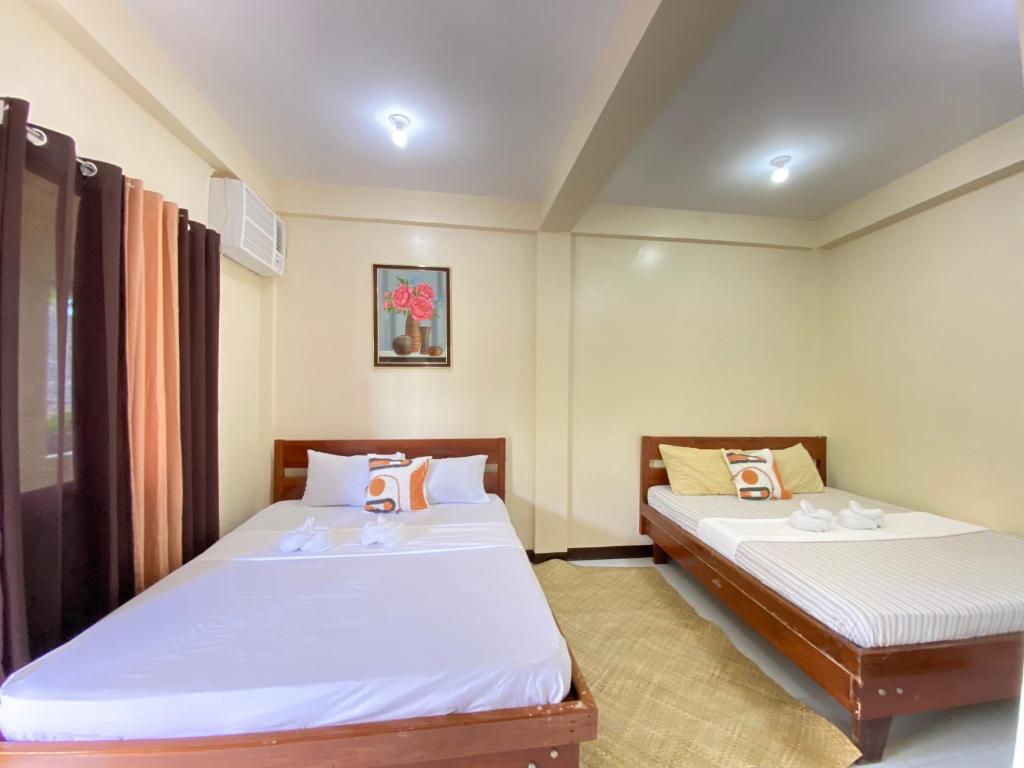 2 camas en una habitación con 2 camas individuales en SHELVES SIARGAO en General Luna