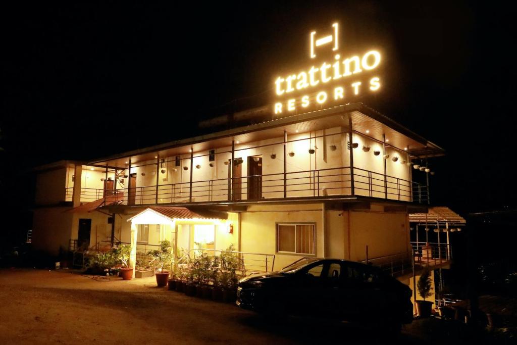 a building with a neon sign on it at night at Trattino Resorts in Panchgani