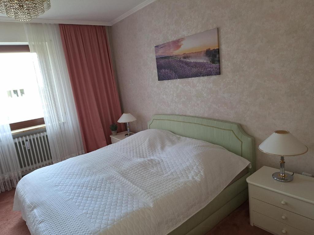 a bedroom with a white bed and a window at Zimmer mit Sonnenaufgang und ruhiger Innenhof bei Koberstein in Tutzing