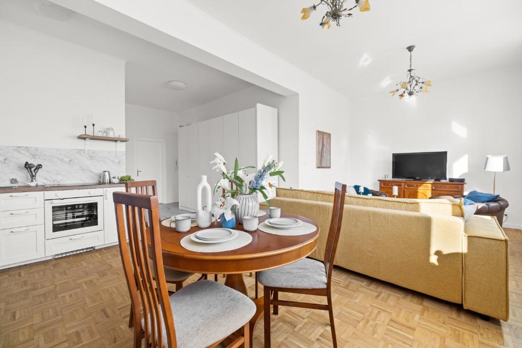 a kitchen and living room with a table and a couch at Apartament Bursztynowy in Gdańsk