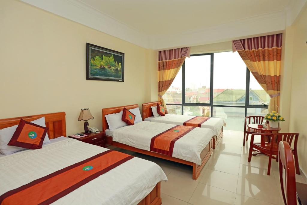 Habitación de hotel con 2 camas y ventana grande. en Đại An Hotel N, en Ninh Binh