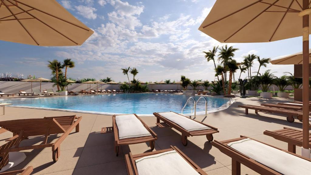 una piscina in un resort con tavoli e ombrelloni di AluaSoul Costa Adeje ad Adeje