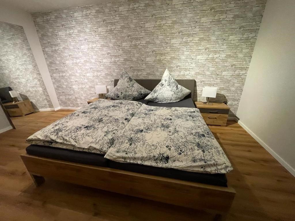 a bedroom with a bed and a brick wall at NEU! Ferienwohnung Kleine Auszeit in Weinsheim