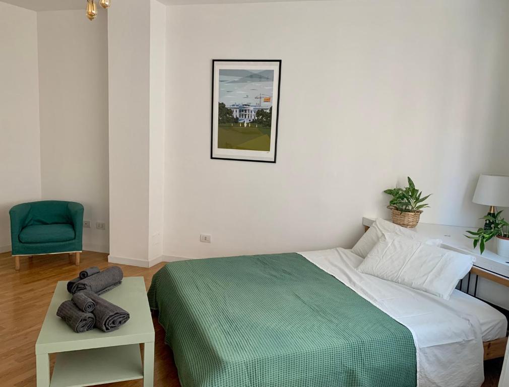 ein Schlafzimmer mit einem Bett, einem Tisch und einem Stuhl in der Unterkunft City Apartment Acqui Terme in Acqui Terme