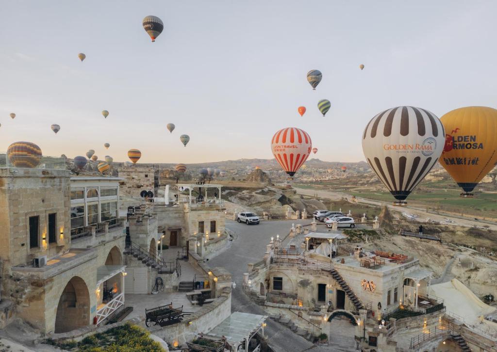 un grupo de globos de aire caliente volando sobre una ciudad en Azure Cave Suites - Cappadocia, en Göreme