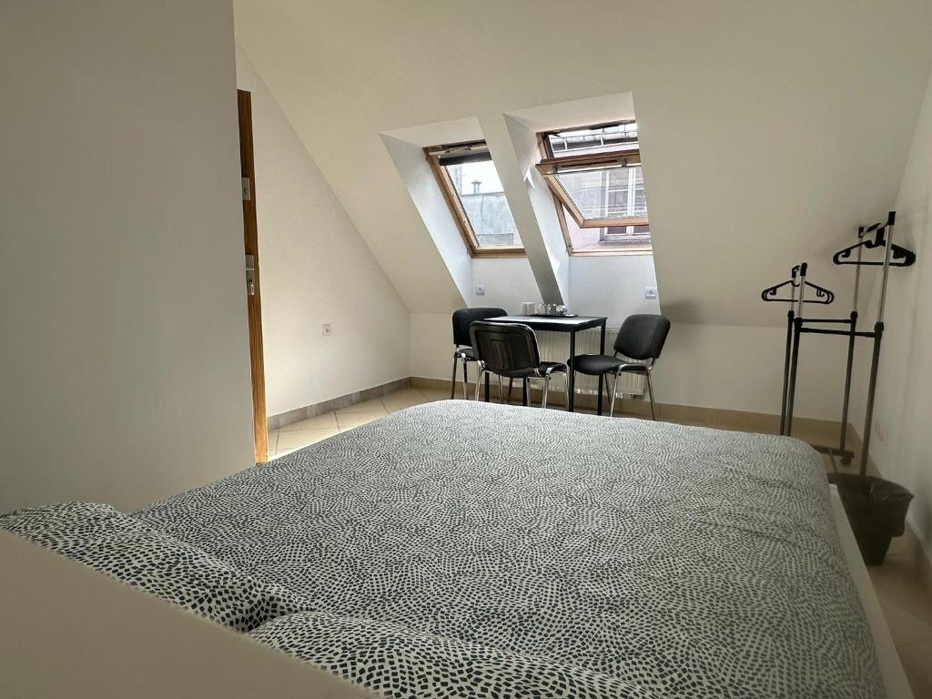 een slaapkamer met een bed en een tafel en stoelen bij Apartamenty Gołębia-Budget in Poznań