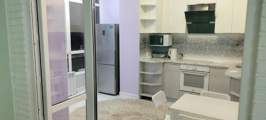 uma pequena cozinha com um frigorífico e uma mesa em Аренда 2-х комнатной квартиры в г.Астана, Казахстан em Taldykolʼ