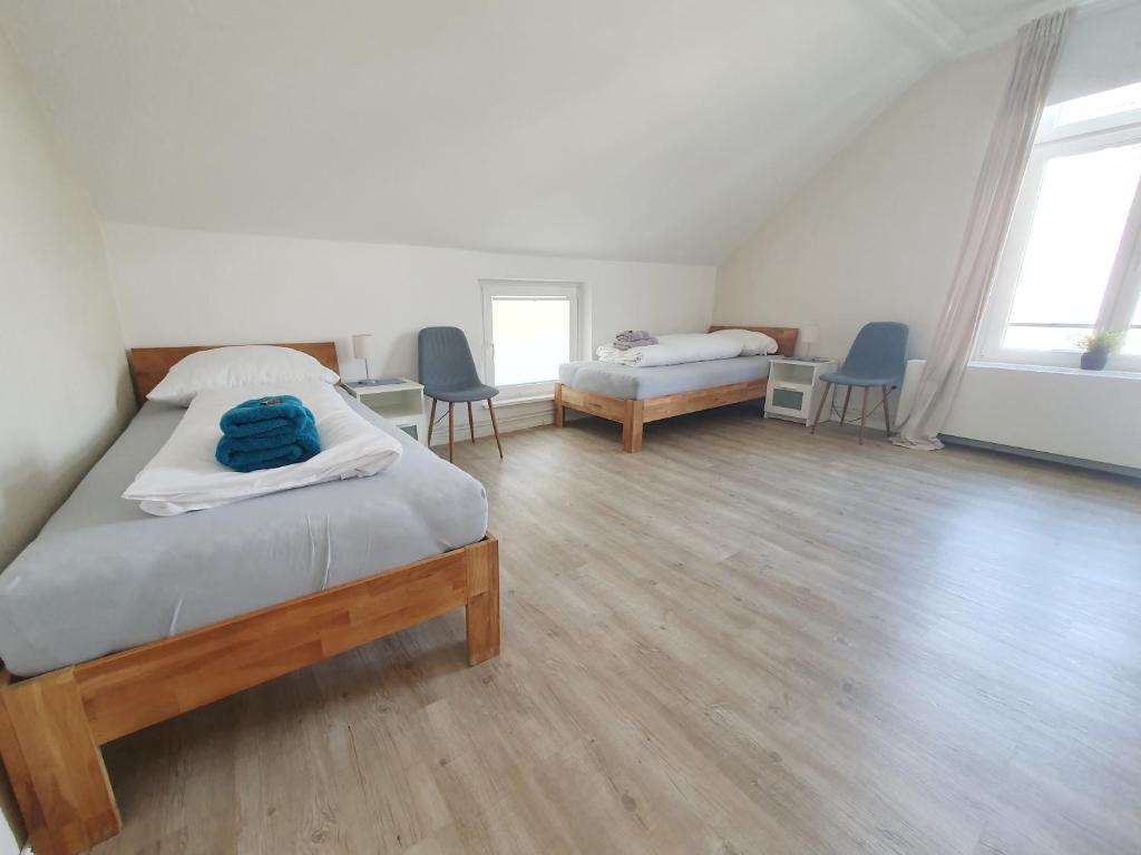 sypialnia z 2 łóżkami i 2 krzesłami w obiekcie Ferienwohnung Stadtvilla - charmante Gemütlichkeit w mieście Bad Oldesloe
