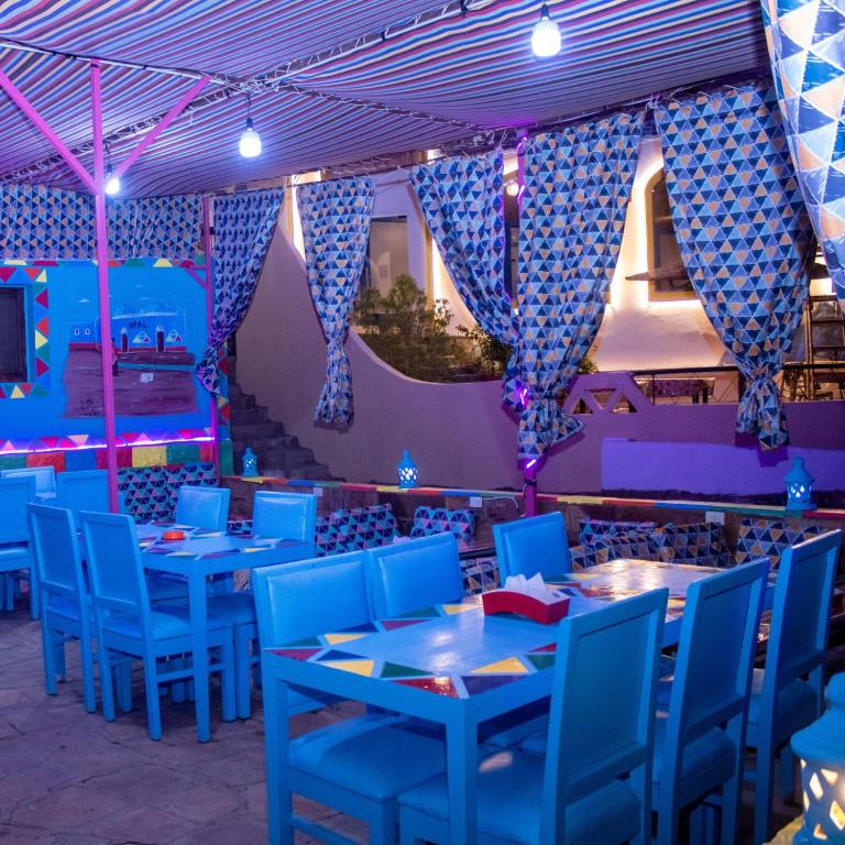 una sala da pranzo con tavoli blu e sedie blu di Opal privat nubian hotel a Aswan