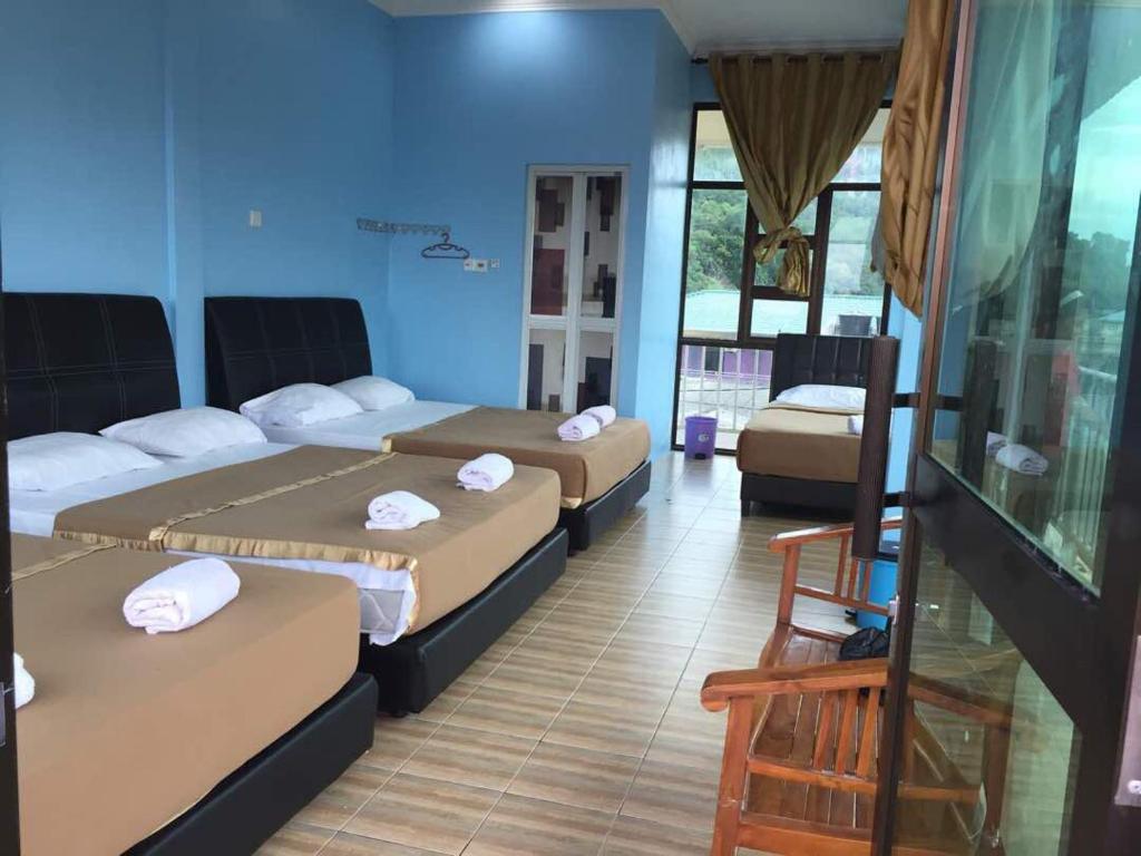 a room with three beds in a room at JV Inn Perhentian in Kampong Pasir Hantu