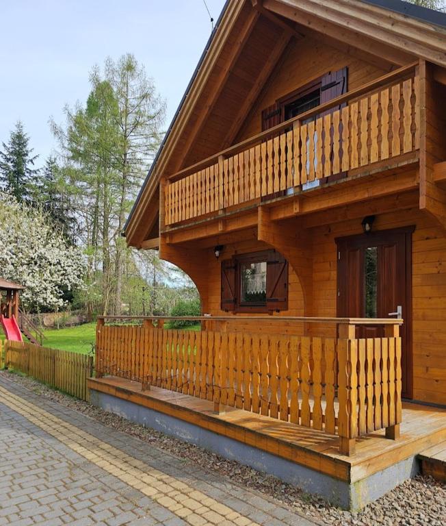 a wooden house with a balcony and a porch at Poranek Pieniński in Krościenko