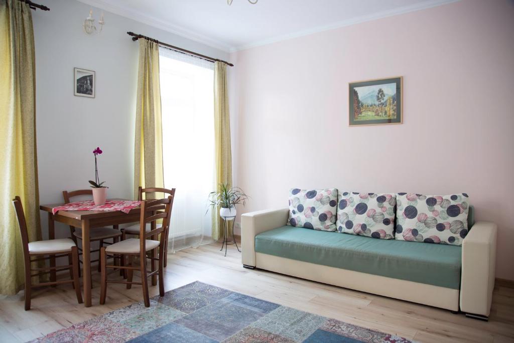 ein Wohnzimmer mit einem Sofa und einem Tisch in der Unterkunft Seek and Hide - Ilse's Hideaway in Braşov
