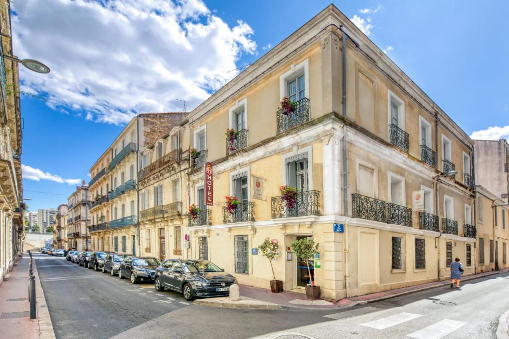a street with cars parked in front of a building at Hotel d'Aragon - Place de la Comédie in Montpellier