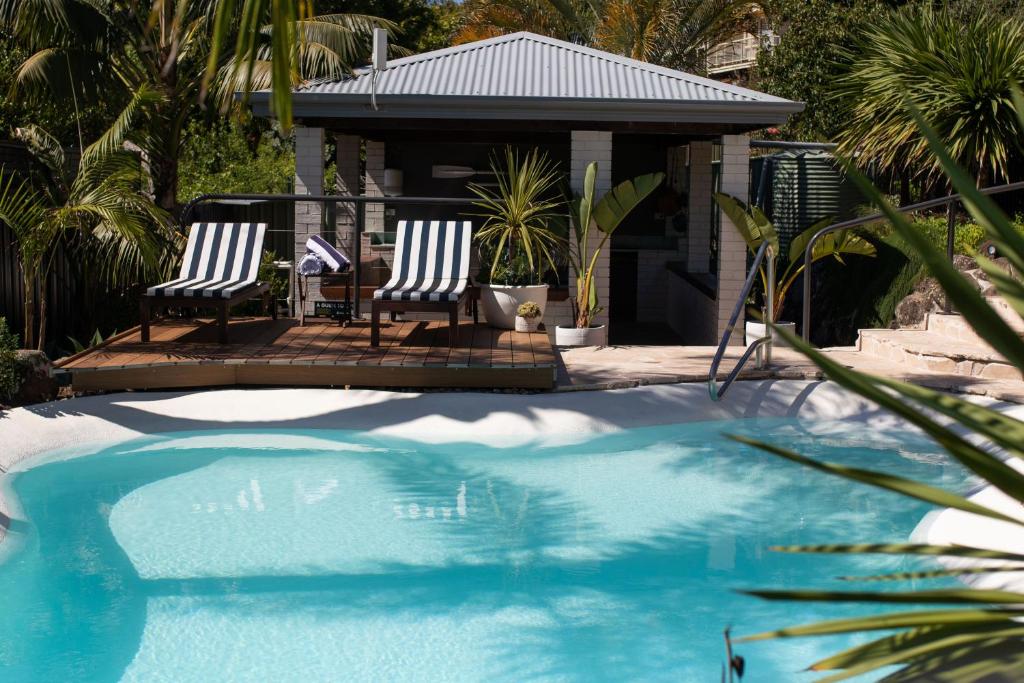 2 sillas sentadas junto a una piscina en Mollymook Seascape Motel and Apartments, en Mollymook