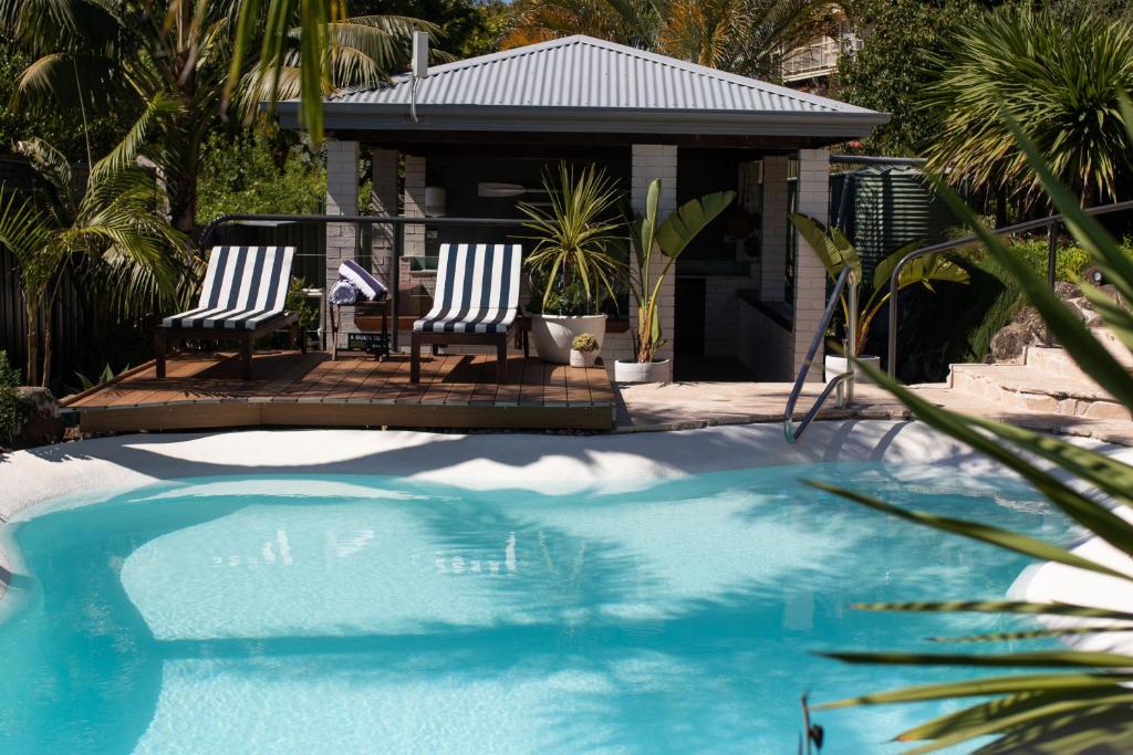 two chairs sitting next to a swimming pool at Mollymook Seascape Motel and Apartments in Mollymook