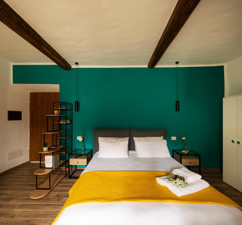 a bedroom with a large bed with a green wall at All'Ombra della Torre in Viterbo