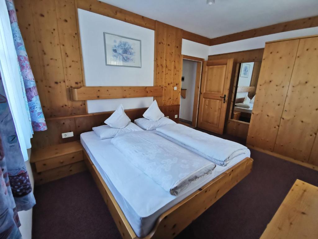 - une chambre avec un grand lit et des murs en bois dans l'établissement Rastenfeldhof, à Parcines