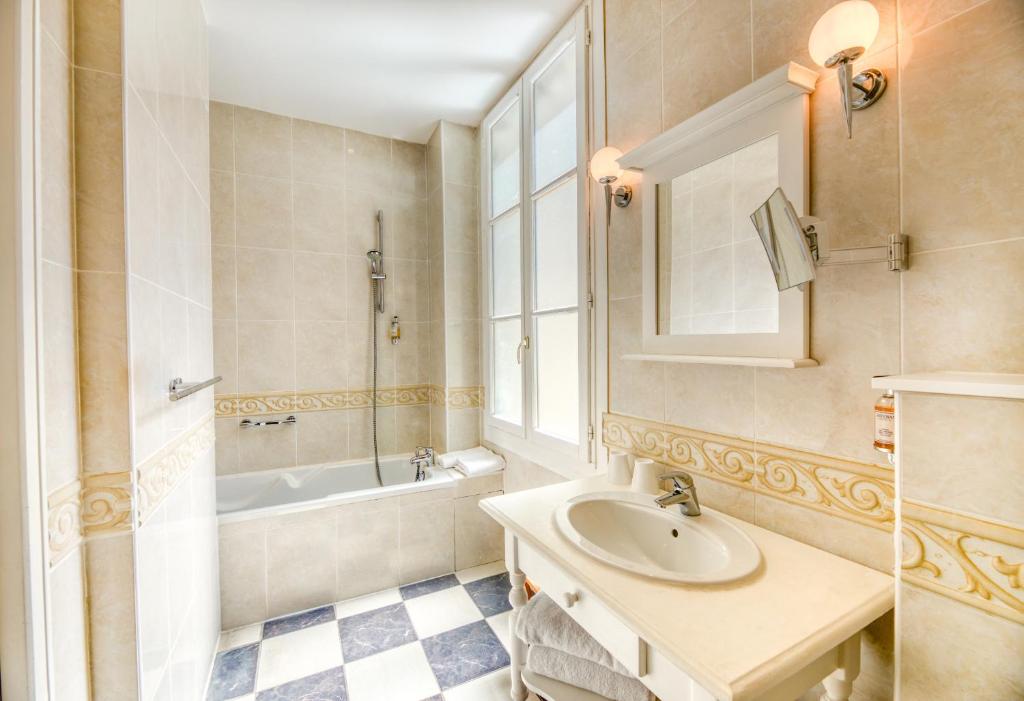 a bathroom with a sink and a tub and a mirror at Hotel d'Aragon - Place de la Comédie in Montpellier
