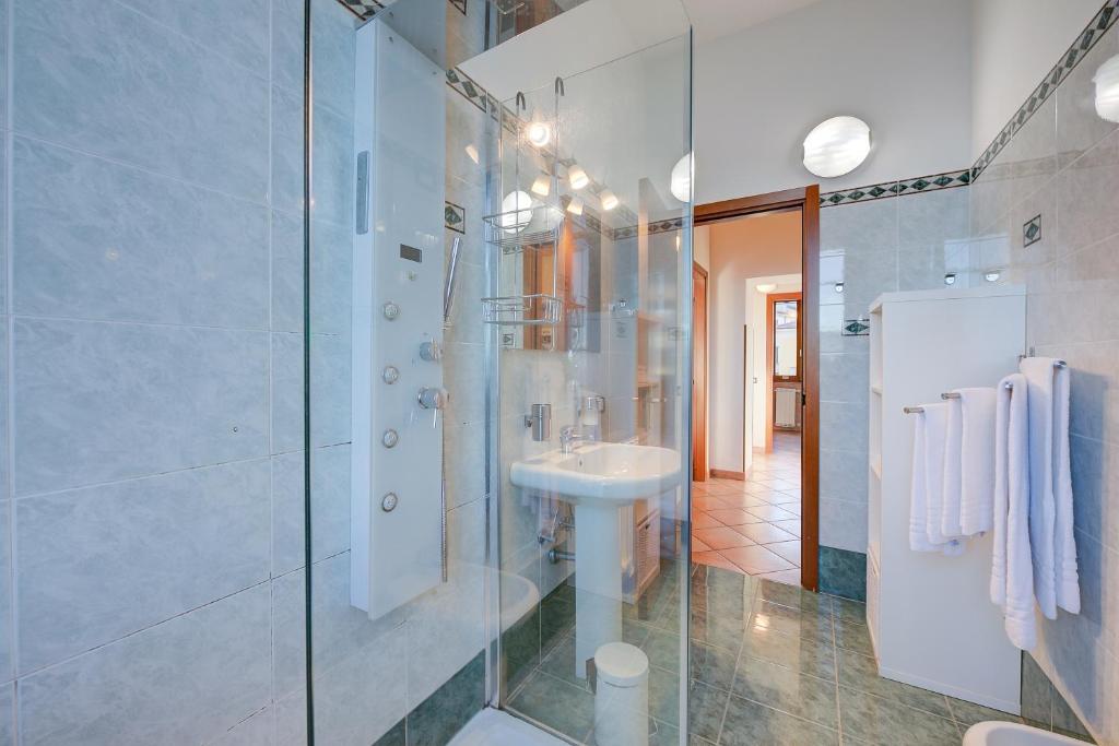 bagno bianco con lavandino e doccia di Aparthotel Arona ad Arona