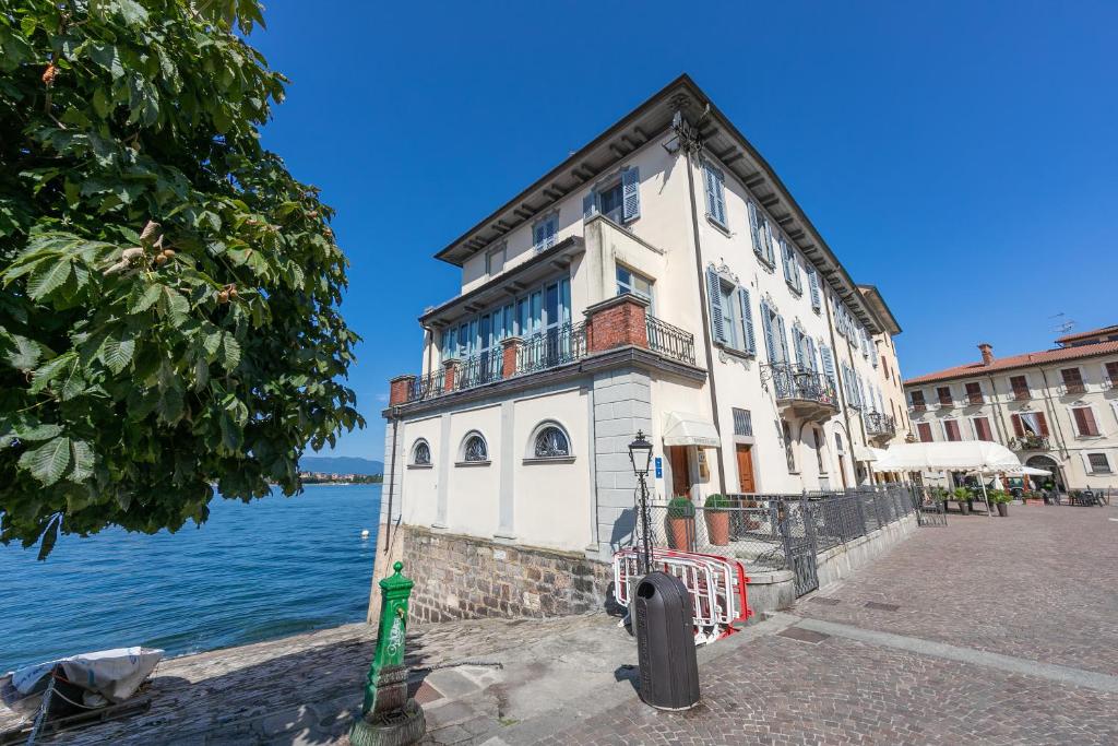 een gebouw aan de kant van een waterlichaam bij Aparthotel Arona - Happy Rentals in Arona