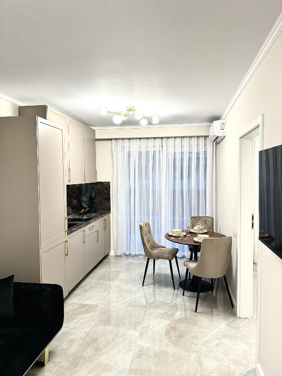 uma cozinha e sala de jantar com mesa e cadeiras em Luxury RA Apartment em Oradea