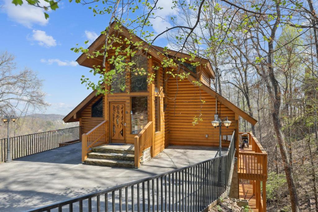 a log cabin with a porch and a fence at Emerald City Lights #203 in Gatlinburg