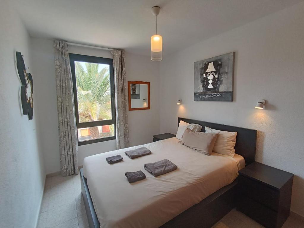 a bedroom with a large bed with two pillows on it at Apartamento SUMMER Complex Amaya Fuerteventura in Costa de Antigua
