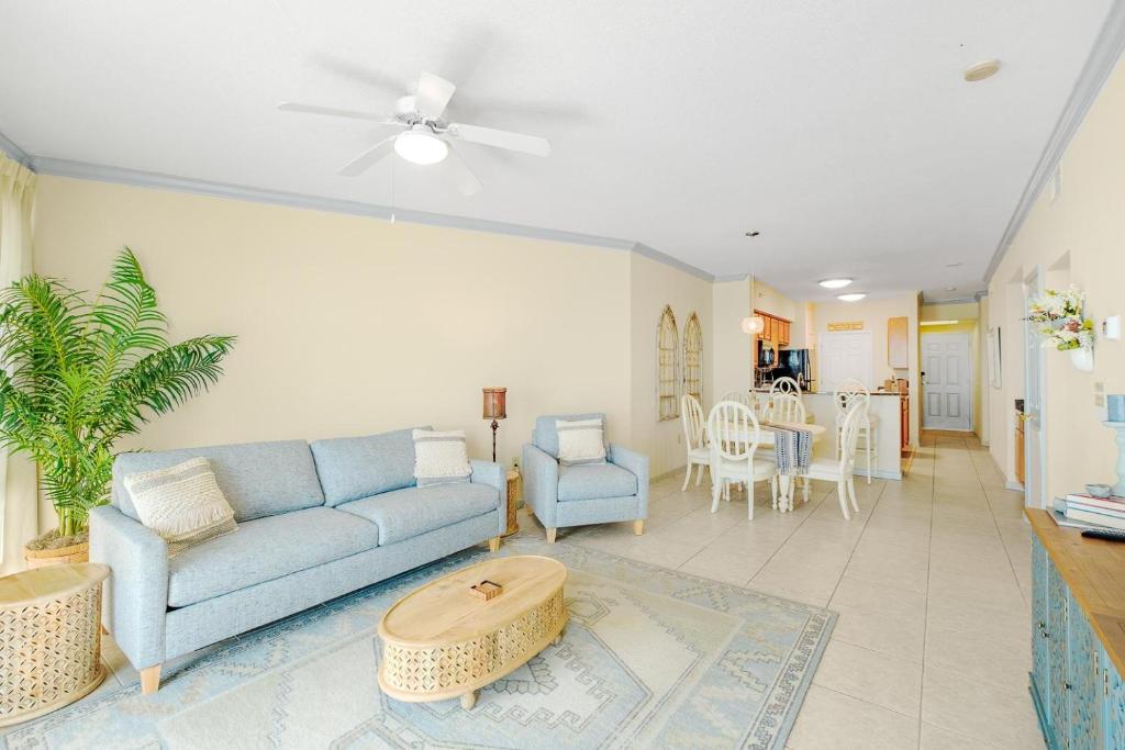 een woonkamer met een blauwe bank en een tafel bij Legacy I 907 in Gulfport