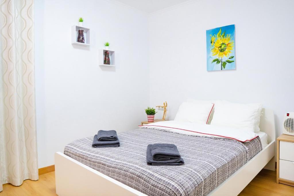 a white bedroom with a bed with two towels on it at Grandera Apart`s - Sollana 18 in Valencia