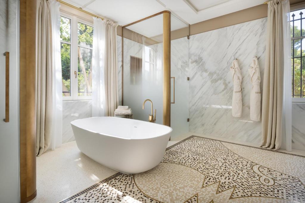 a bathroom with a large white tub and a shower at Grand-Hôtel du Cap-Ferrat, A Four Seasons Hotel in Saint-Jean-Cap-Ferrat
