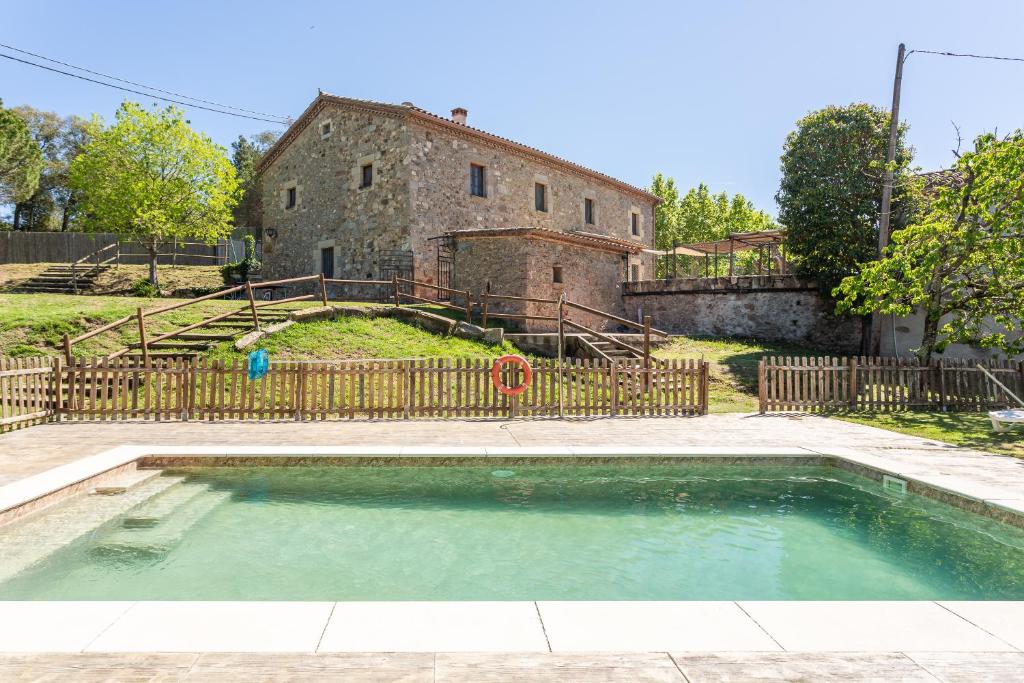 uma piscina vazia em frente a um edifício antigo em Can Malràs em Massanas