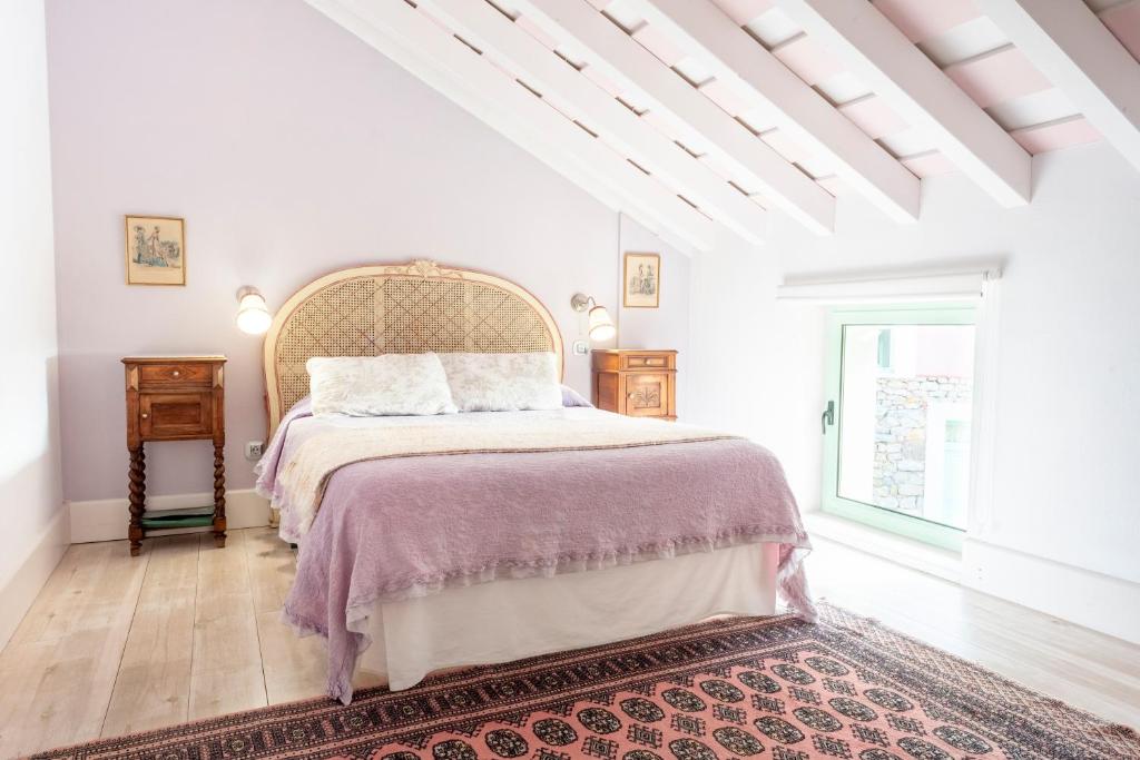 a white bedroom with a large bed and a window at Posada Rolisas in Polanco