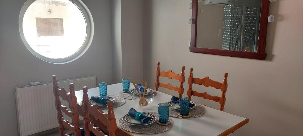 einen Esstisch mit Stühlen und einem Spiegel in der Unterkunft Momenti Felici 2 in Artemida