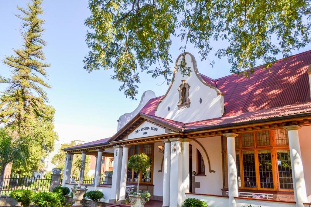 an old building with a red roof at De Avond Rust in Oudtshoorn