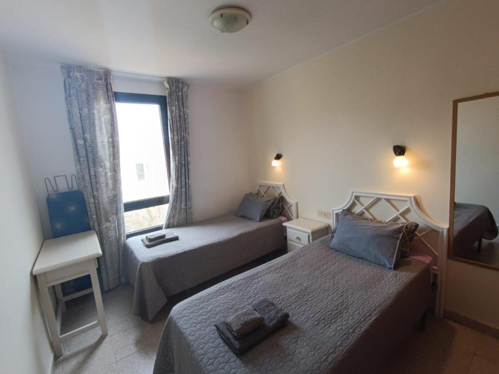 ein Hotelzimmer mit zwei Betten und einem Fenster in der Unterkunft Apartamento SUNNY Complex Amaya Fuerteventura in Costa de Antigua