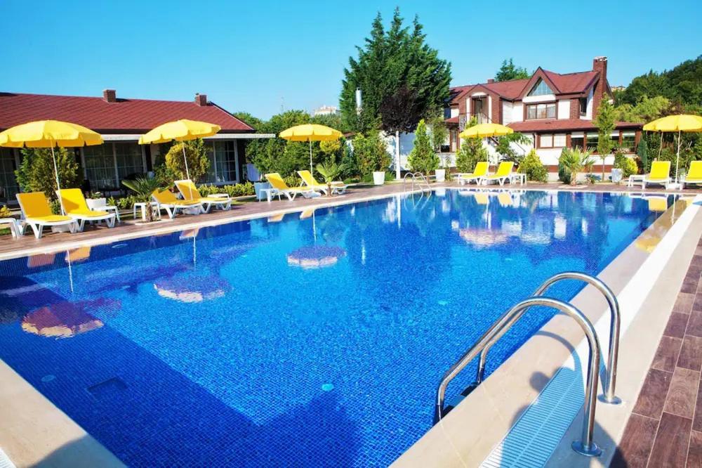 una gran piscina azul con sillas y sombrillas en 216 North Hotel, en Agva