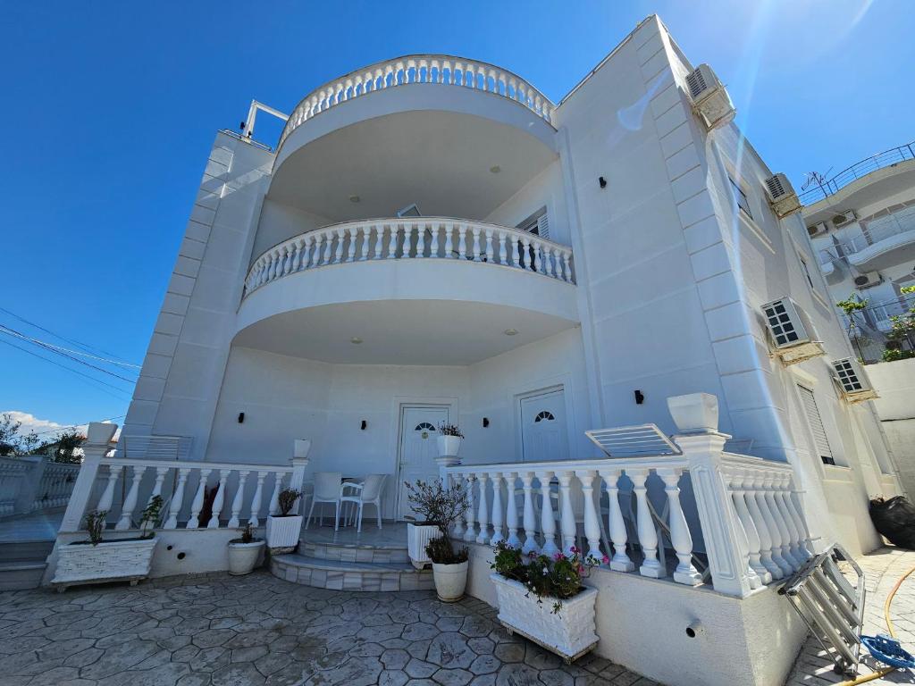 a large white house with stairs and a balcony at Villa A & A in Ksamil