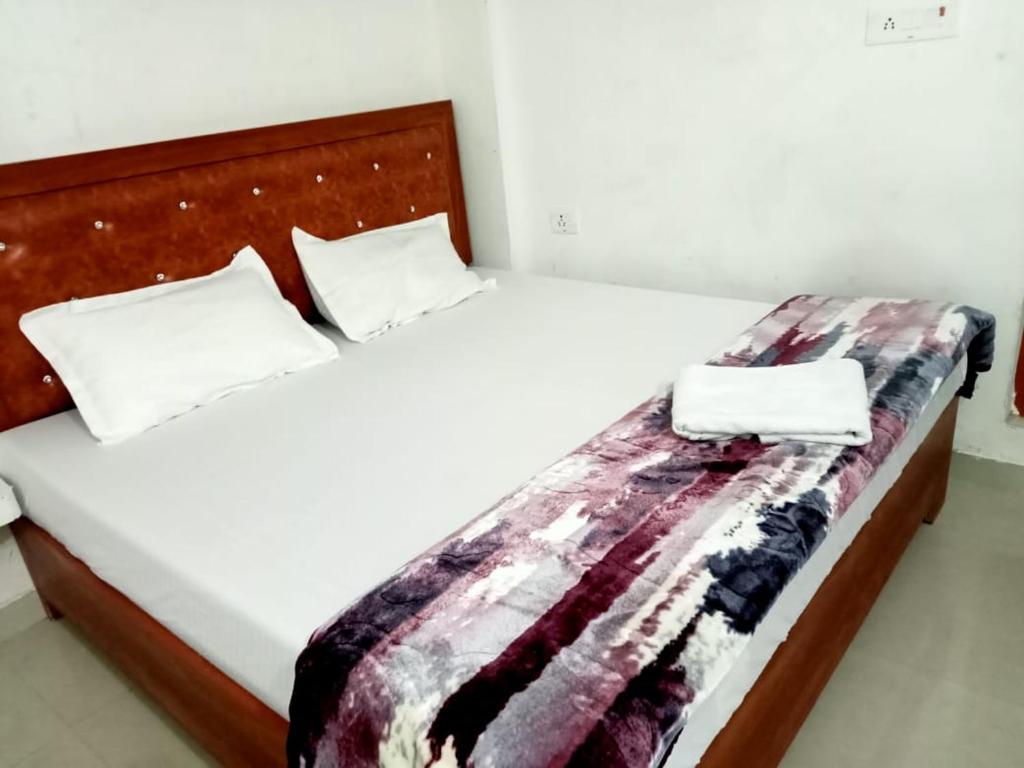Hotel maa janki palace ayodhya في Ayodhya: سرير عليه وسادتين وبطانية