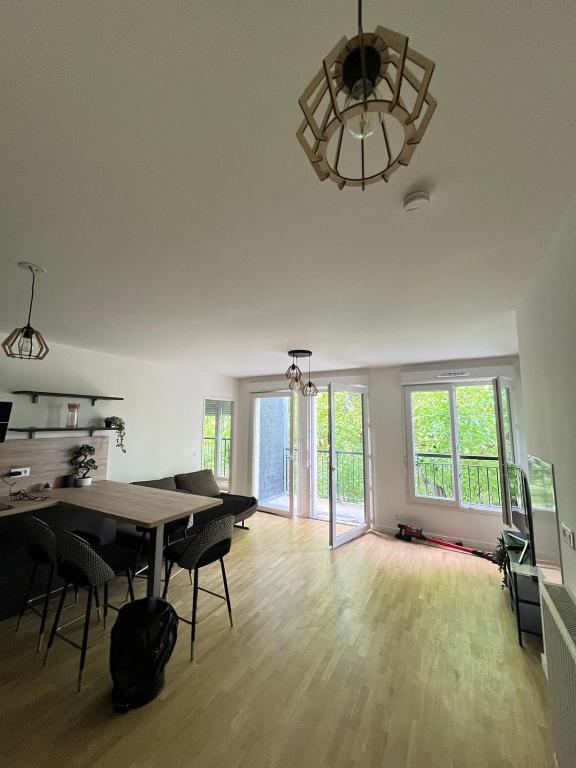 - un salon vide avec une table et des chaises dans l'établissement 2 pièces standing entre Disneyland et Paris, à Neuilly-Plaisance