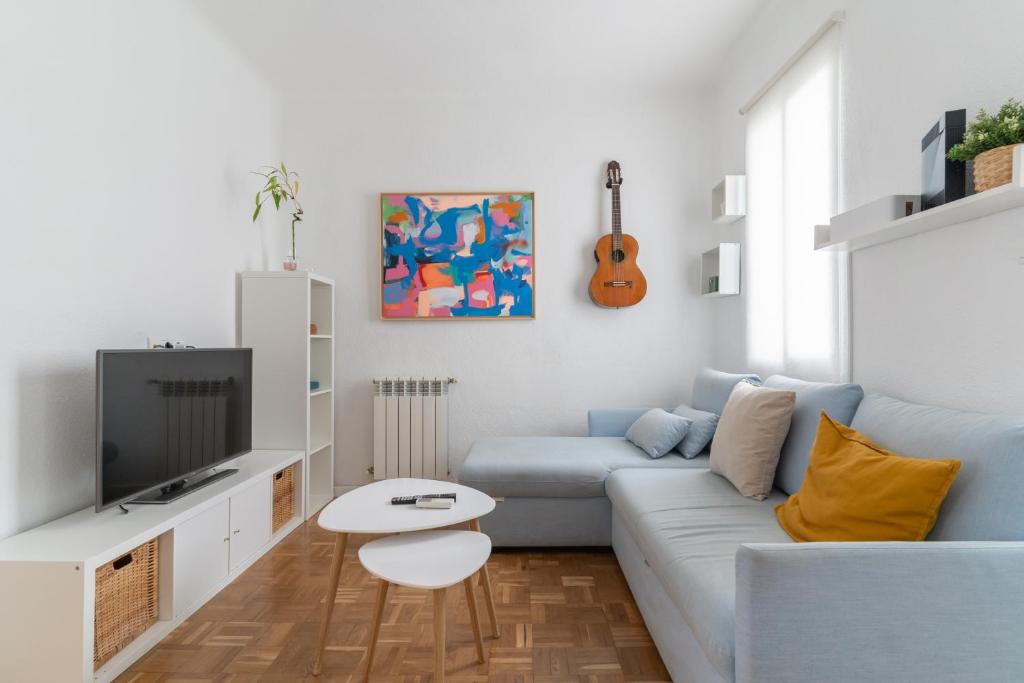 a living room with a blue couch and a tv at Bright apartment-2Bedrooms 1Bathroom-Delicias in Madrid